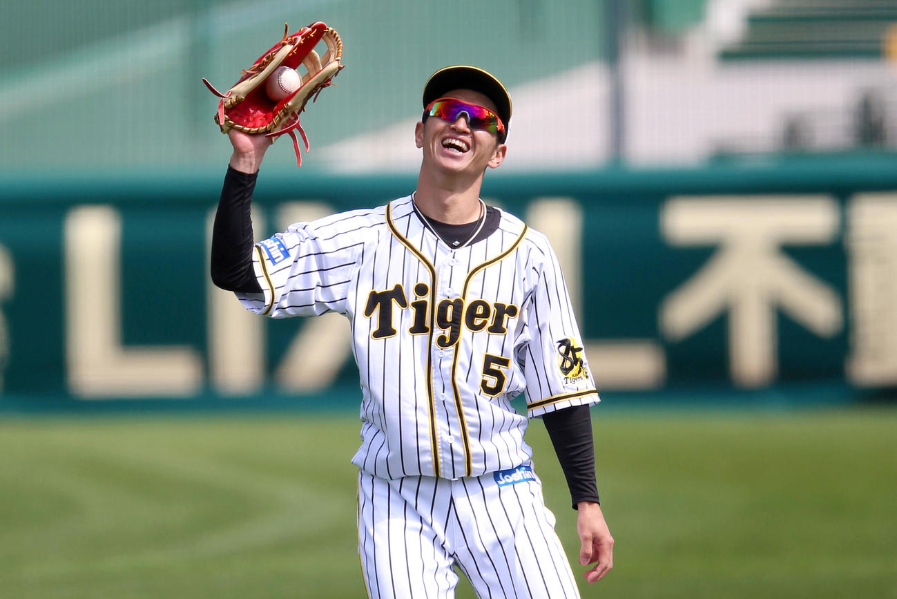 甲子園で練習する近本は外野で捕球し笑顔を見せる（撮影・上山淳一）