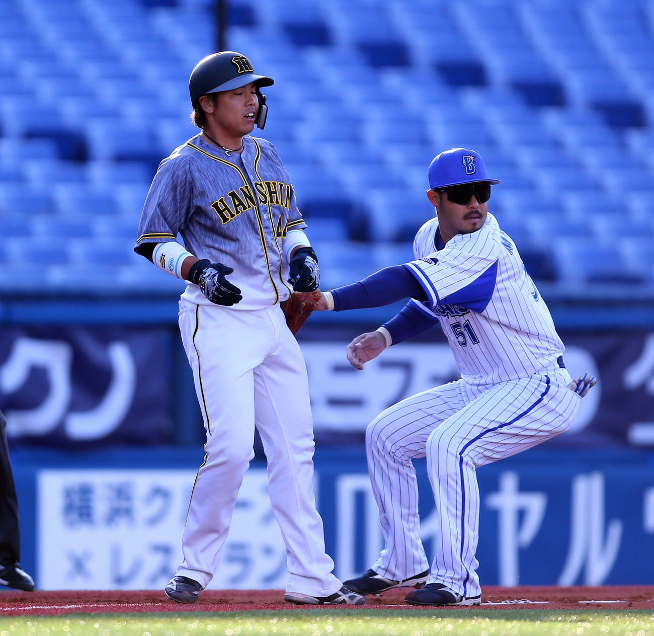 DeNA対阪神　2回表阪神1死一、三塁、木浪の一ゴロで三本間に挟まれ宮崎（右）にタッチアウトにされる梅野（撮影・大野祥一）