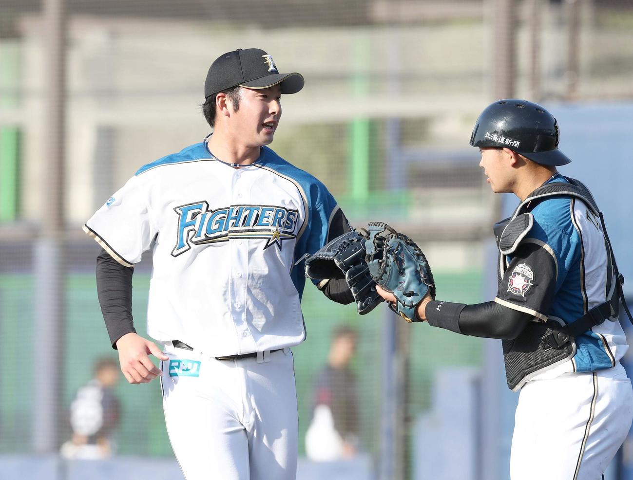 日本ハム対西武　8回に登板し打者を3人で抑え捕手田宮（右）とタッチする長谷川（撮影・黒川智章）