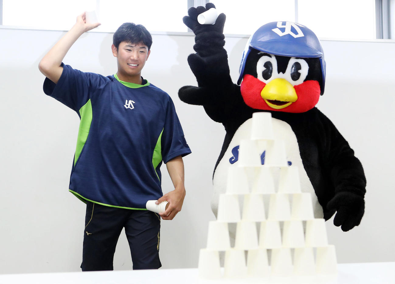 遊びながらできる練習法で、つば九郎といっしょに紙コップを投げる奥川（撮影・狩俣裕三）