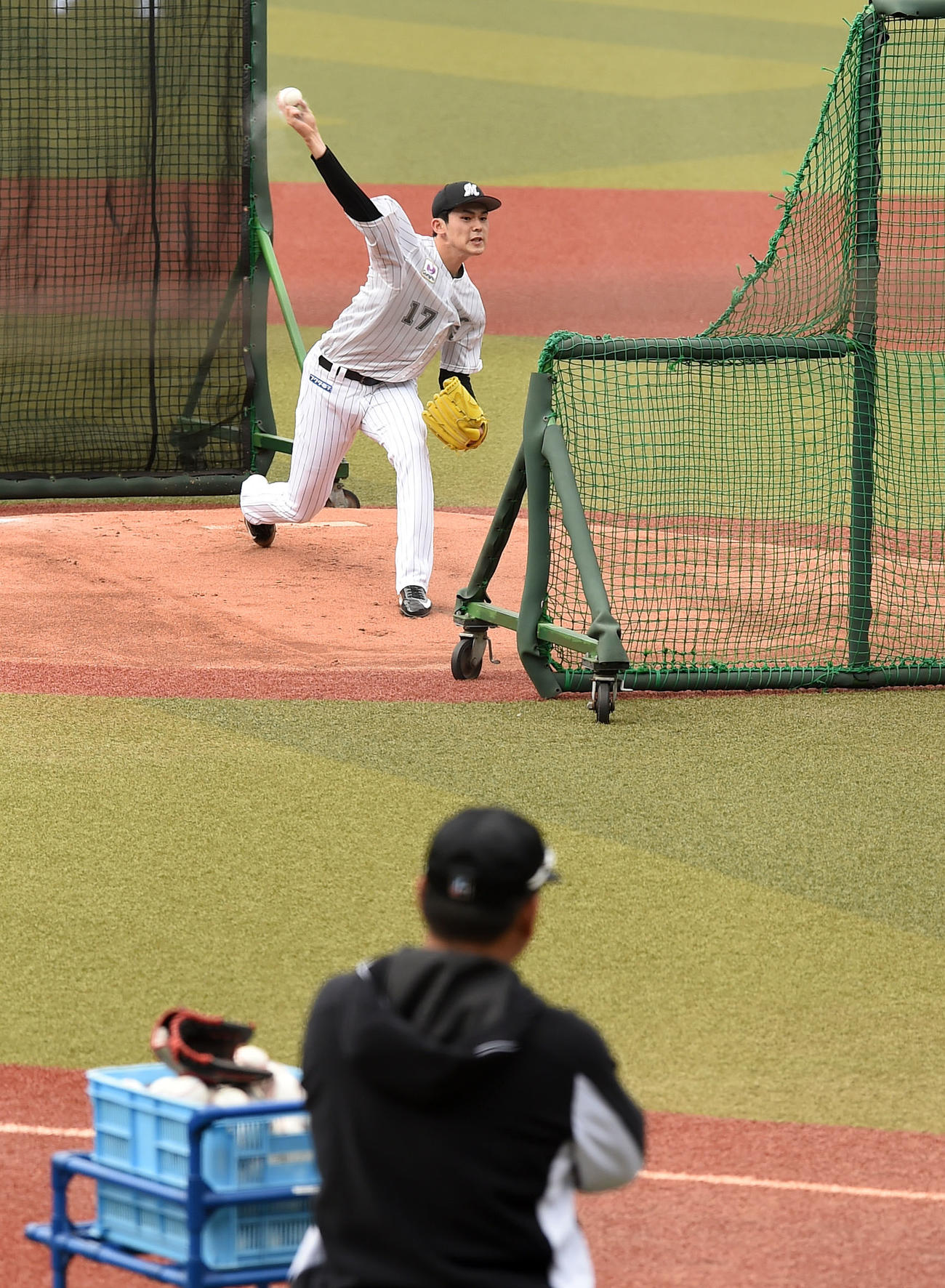 ロッテ井口監督（手前）が見つめる中、変化球を織り交ぜながら打撃投手を務めた佐々木朗（撮影・横山健太）