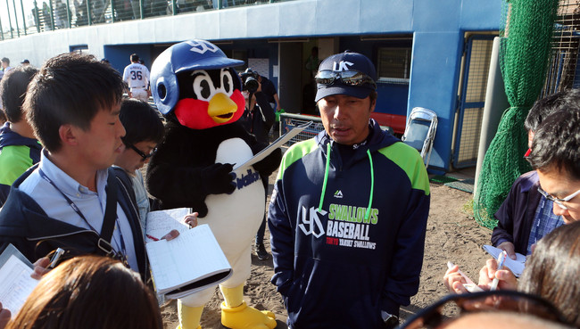 20年2月19日の練習試合　ヤクルト対楽天　試合後、記者の質問に答える高津監督の左後方でメモを取るつば九郎