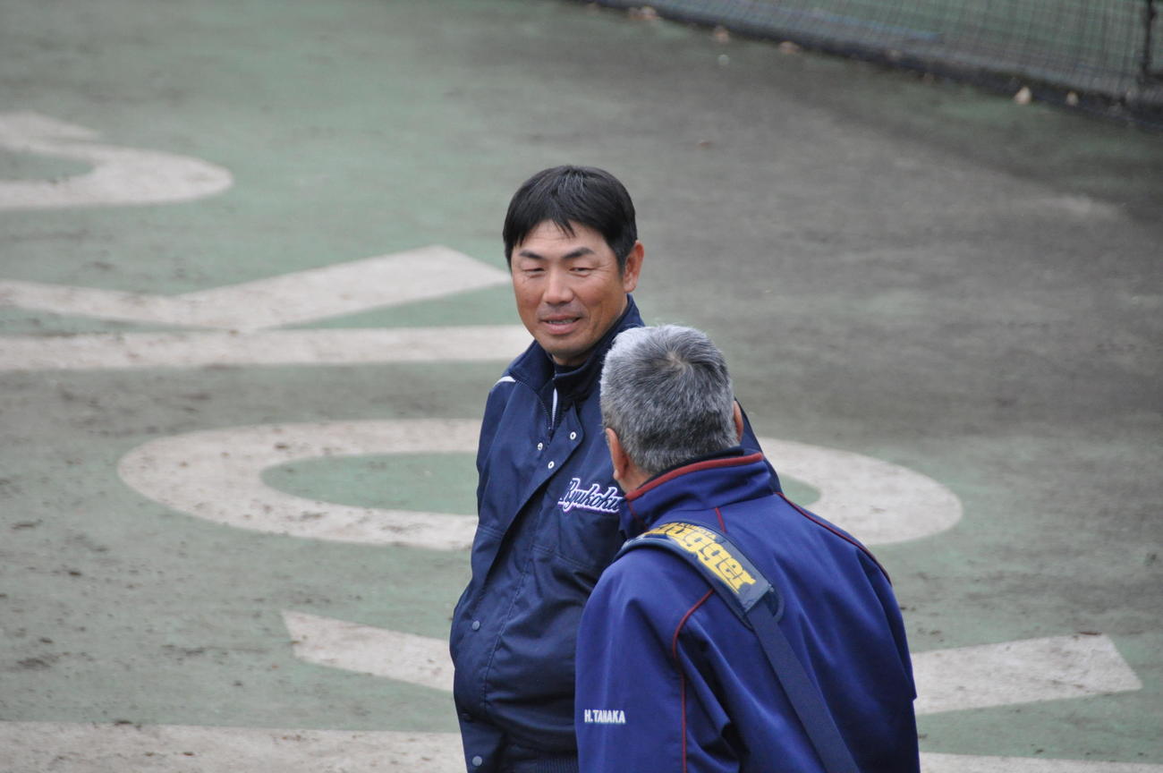 龍谷大の本郷宏樹監督（左）は練習試合後に近大・田中秀昌監督と話をする