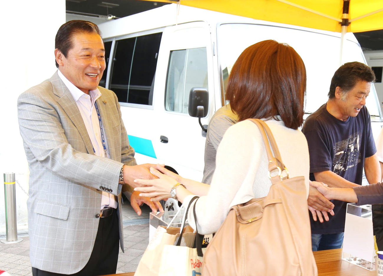 球場外でファンに東日本大震災の義援募金を呼びかける梨田氏（左）、右は川藤氏（2014年9月20日撮影）