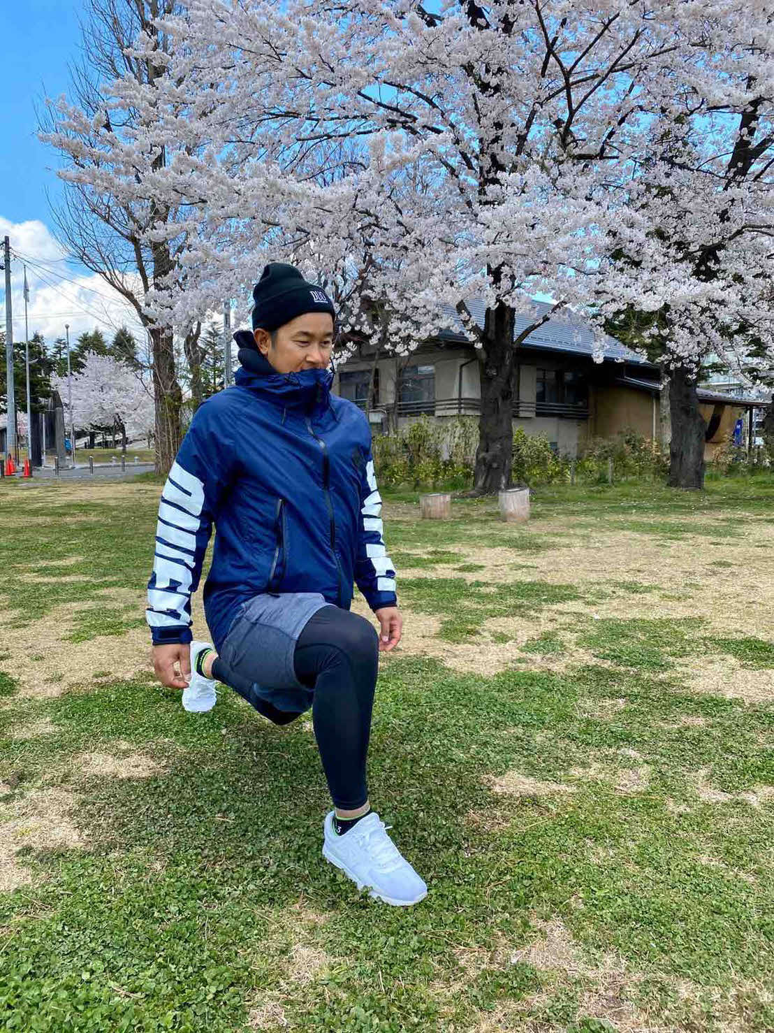 桜の木の下でストレッチを行う楽天銀次（球団提供）