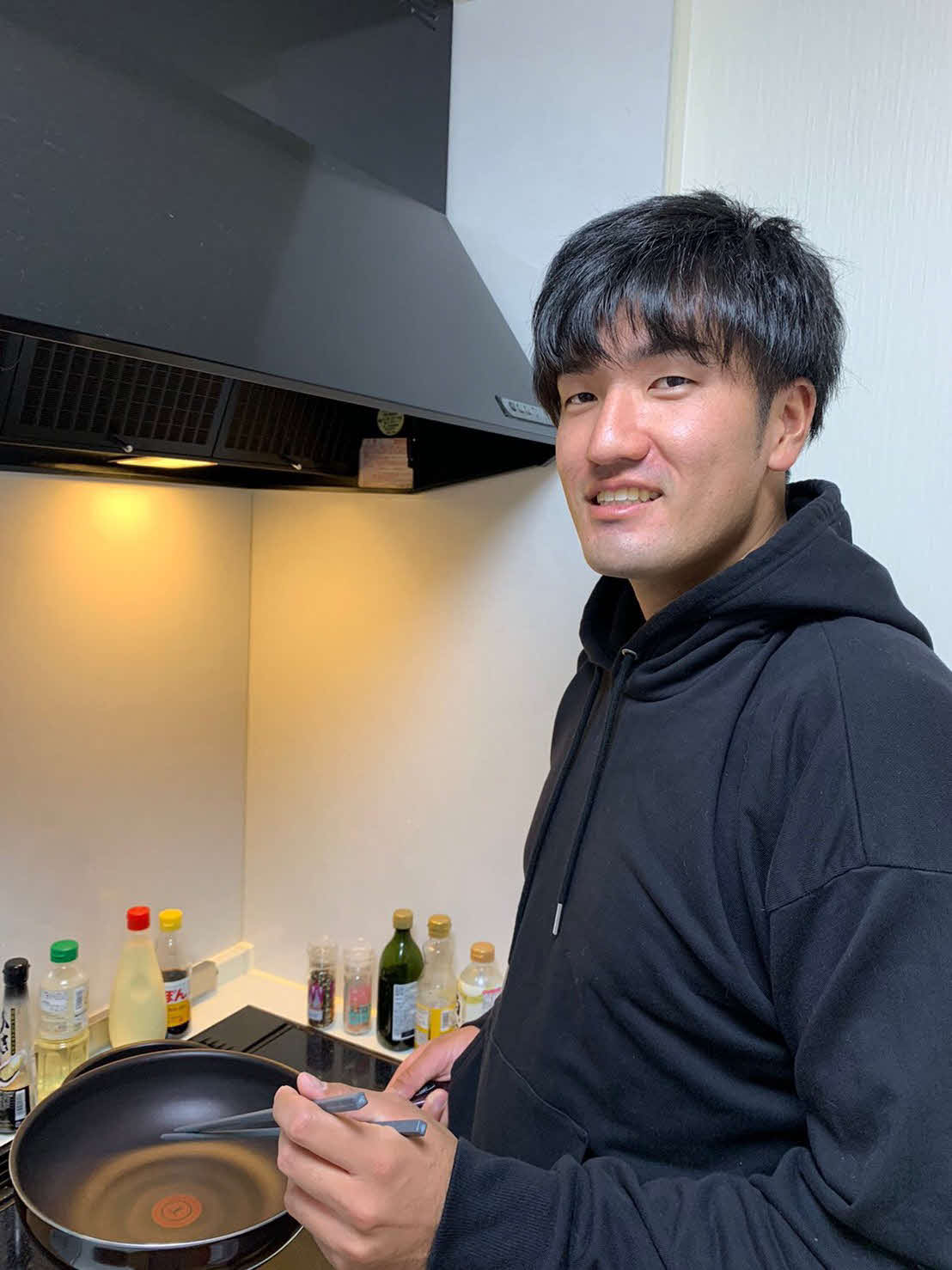自宅のキッチンに立つ楽天弓削（球団提供）