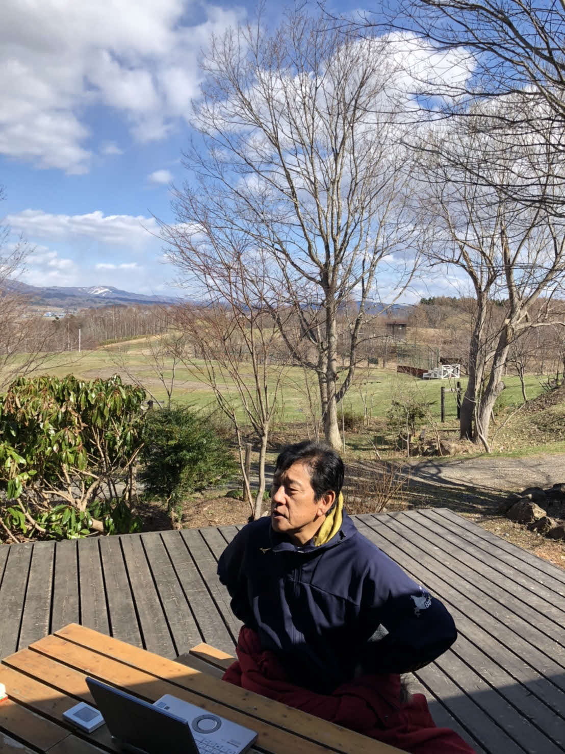 北海道栗山町の栗の樹ファームで野球場をバックにテラスでオンライン取材を受ける日本ハム栗山監督（球団提供）
