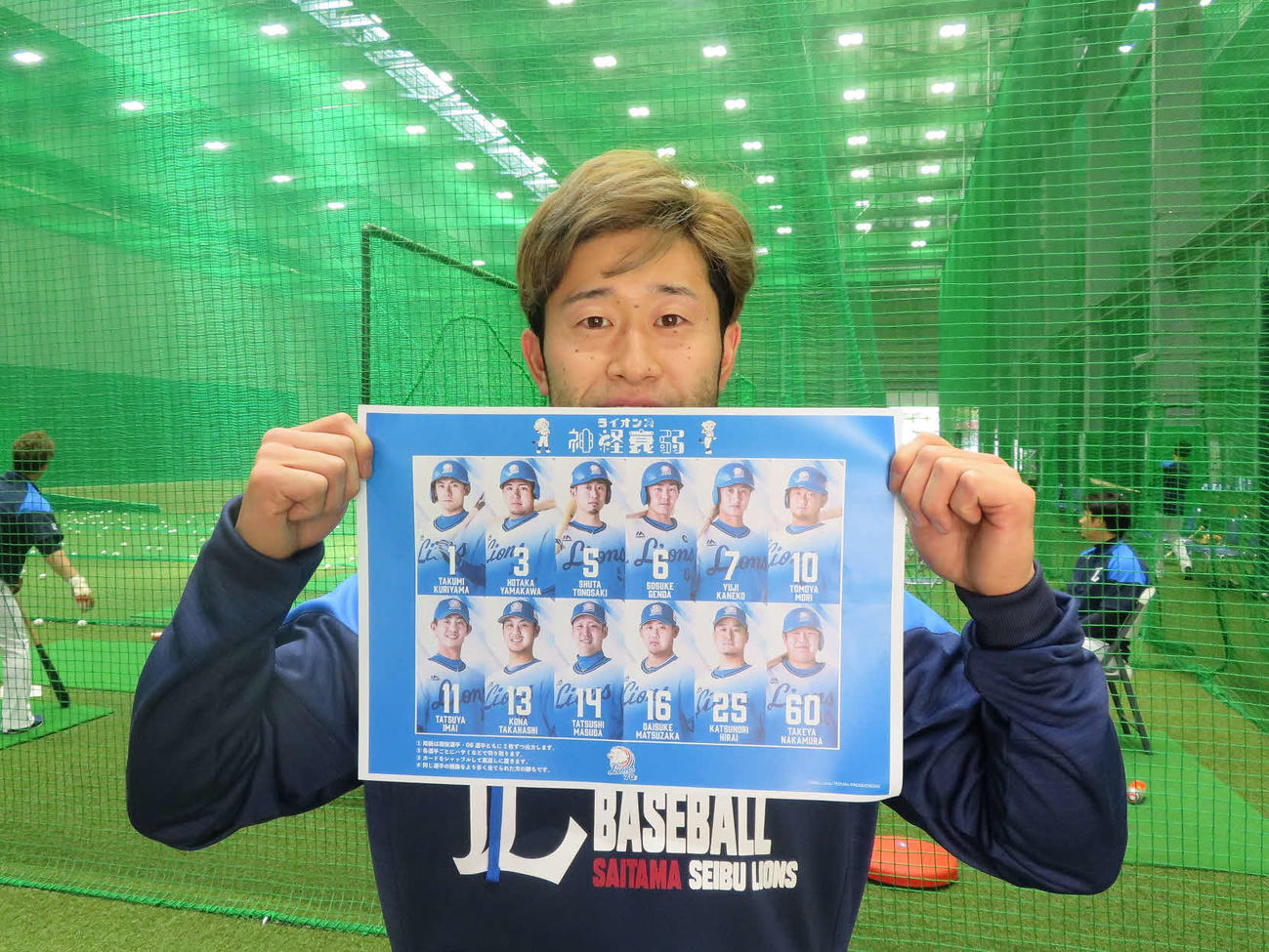 ダウンロードした「ライオンズ神経衰弱　70周年記念版」を手にする西武外崎（球団提供）