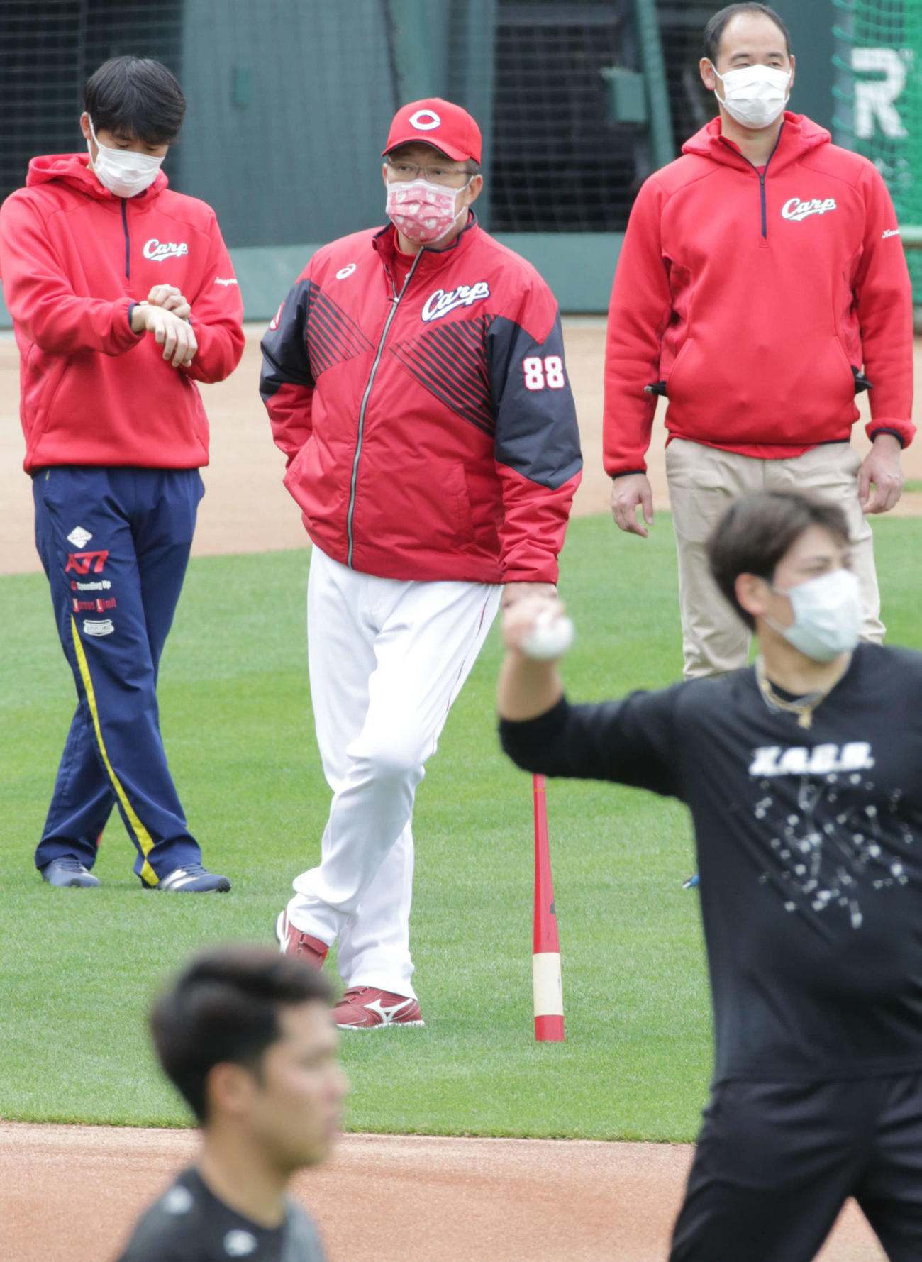 練習を見守る佐々岡真司監督。右手前のマスク姿は九里（撮影・加藤孝規）