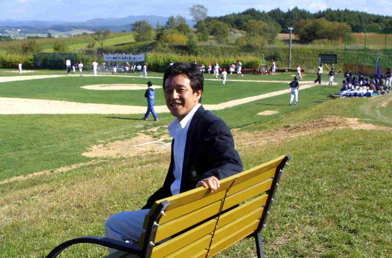 完成したばかりの「栗の樹ファーム」。少年野球場をバックに記念撮影する栗山氏