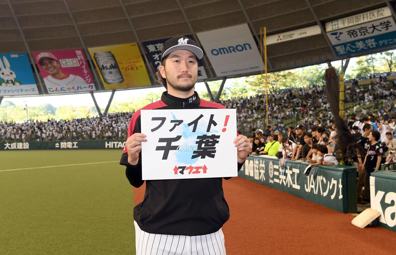 西武対ロッテ　西武に勝利し被災地に向けボードを掲げるロッテ石川（2019年9月16日撮影）