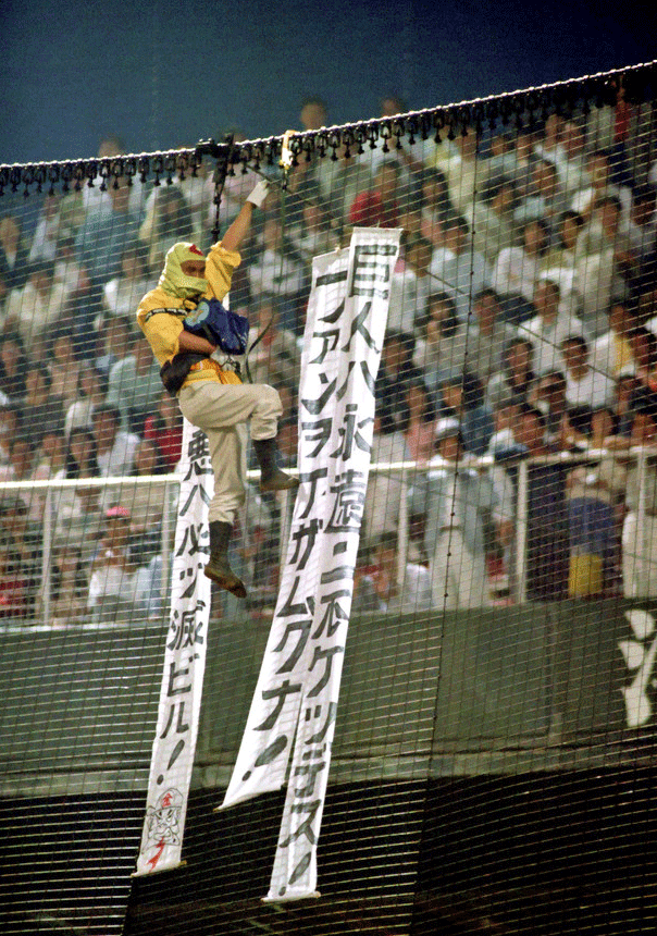 広島球場のバックネットによじ登り垂れ幕をたらす「クモ男」（90年5月12日撮影）