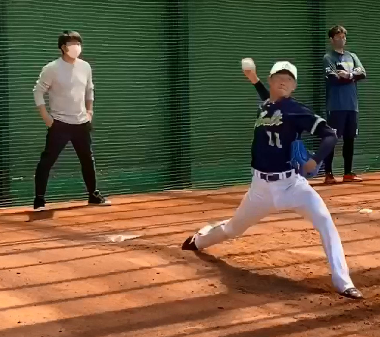 ブルペンで投球練習するヤクルト奥川。左は高津監督（球団提供）