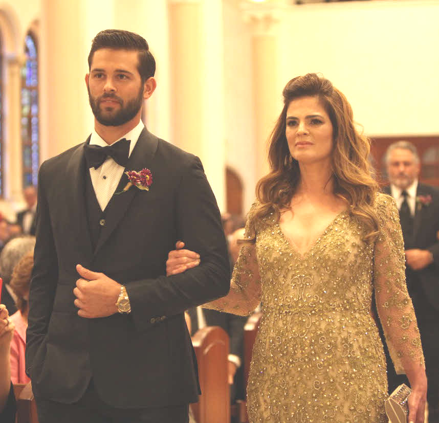 結婚式で母アナベル・マルティネスさんと腕を組んで歩く日本ハムのニック・マルティネス投手（左）（球団提供）