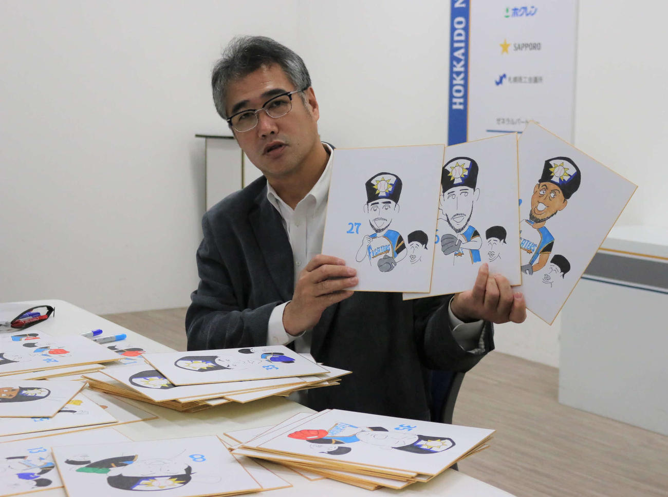 作成中の似顔絵を披露する日本ハム木田投手コーチ（撮影・中島宙恵）