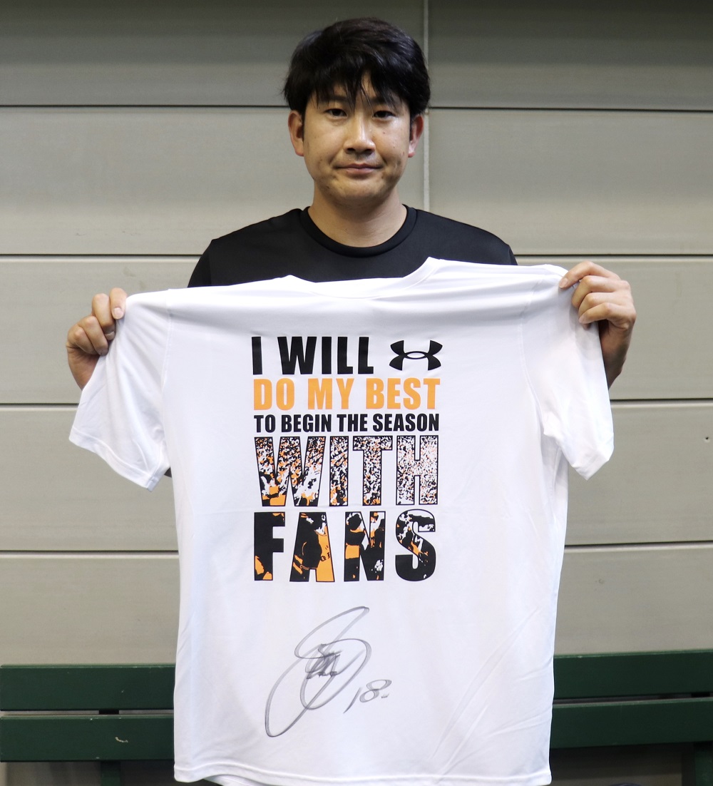 直筆サイン入りの「WITH　FANS」Tシャツを手にする巨人菅野（球団提供）