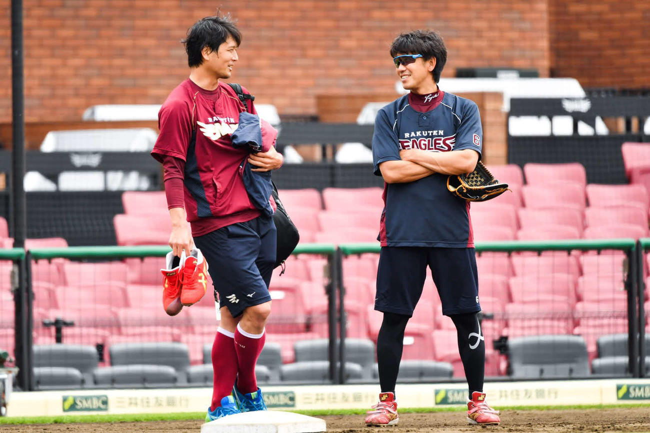 自主練習中に楽天藤田（右）と笑顔で雑談する涌井（左）（球団提供）