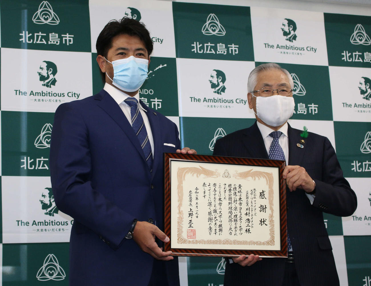 北海道・北広島市の緑葉公園野球場の一部改修に対して北広島市の上野市長から感謝状を受け取った日本ハム稲葉SCO（左）（撮影・木下大輔）