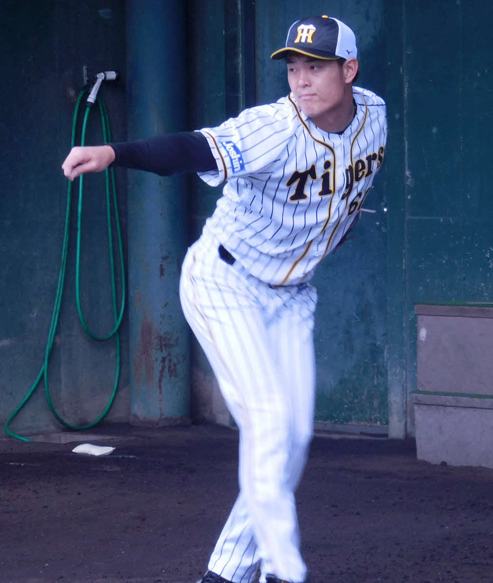 鳴尾浜球場のブルペンで投球練習する望月（球団提供）