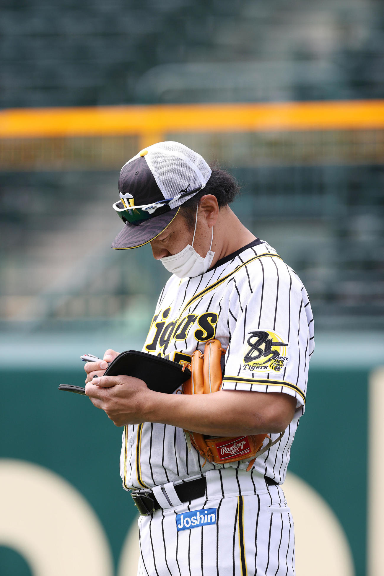 手帳にメモを書く福原投手コーチ（球団提供）