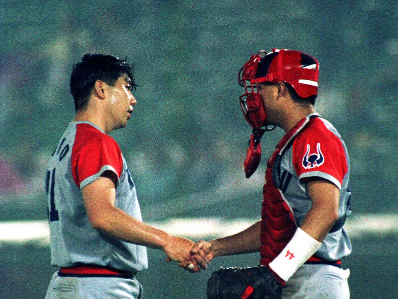 1試合最多16四球を与えながらも完投勝利の野茂（左）は捕手光山と握手（1994年07月01日撮影）