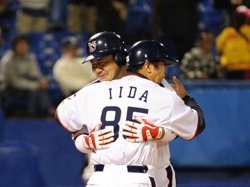 プロ最終打席で本塁打を放った小野公誠(左)は飯田コーチの祝福を受ける