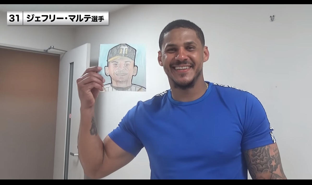 第1回似顔絵コンテストの応募作品を審査するマルテ（阪神タイガース公式YouTubeから）