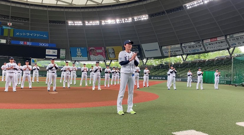 源田主将（手前）を先頭に、医療従事者・介護従事者へ向けて感謝の拍手を送る西武ナインら（球団提供）
