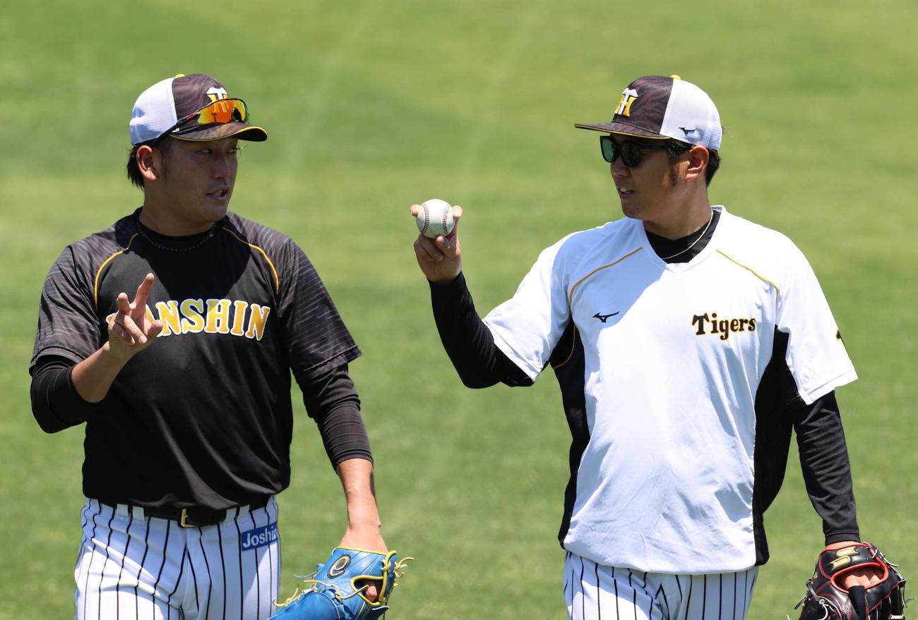 高野圭佑（左）にフォークの握りを見せる西勇輝（撮影・清水貴仁）
