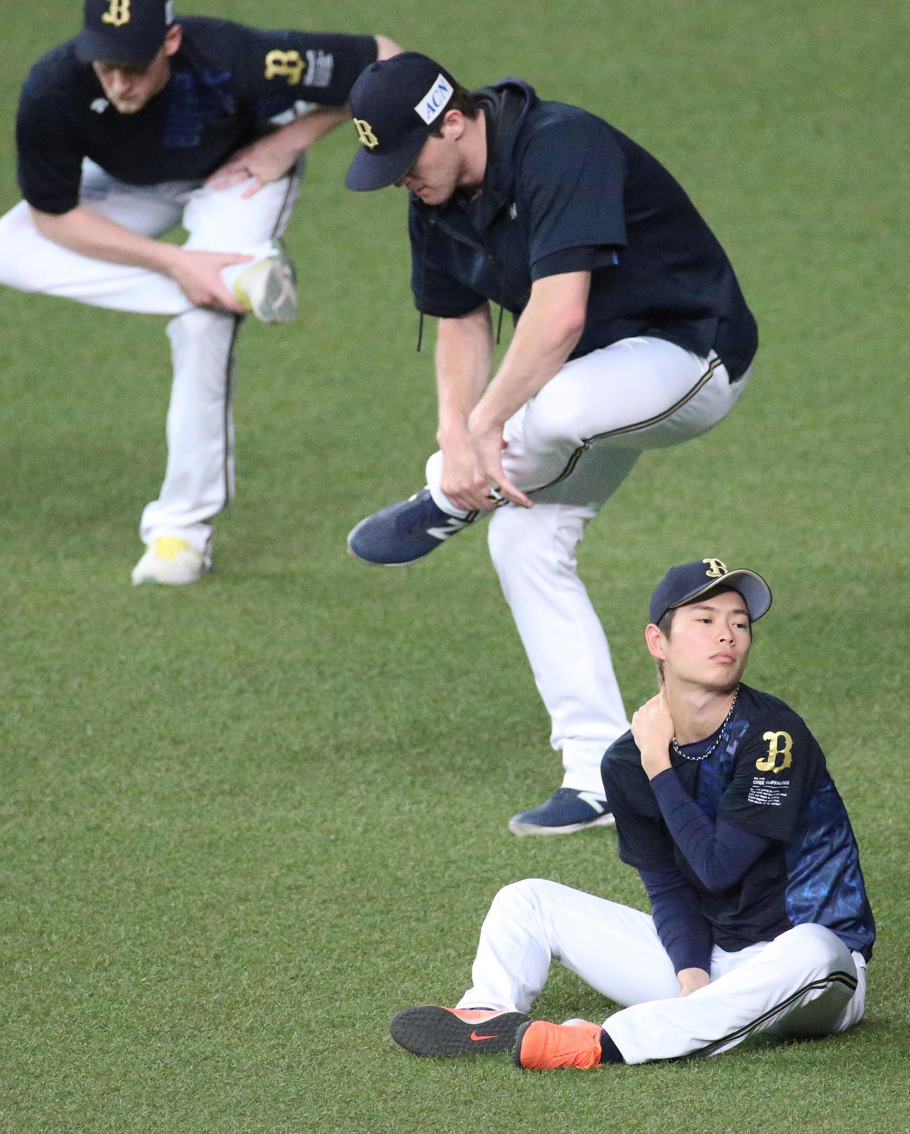 山岡（手前）は投手陣がストレッチする中、首を気にする（撮影・上山淳一）