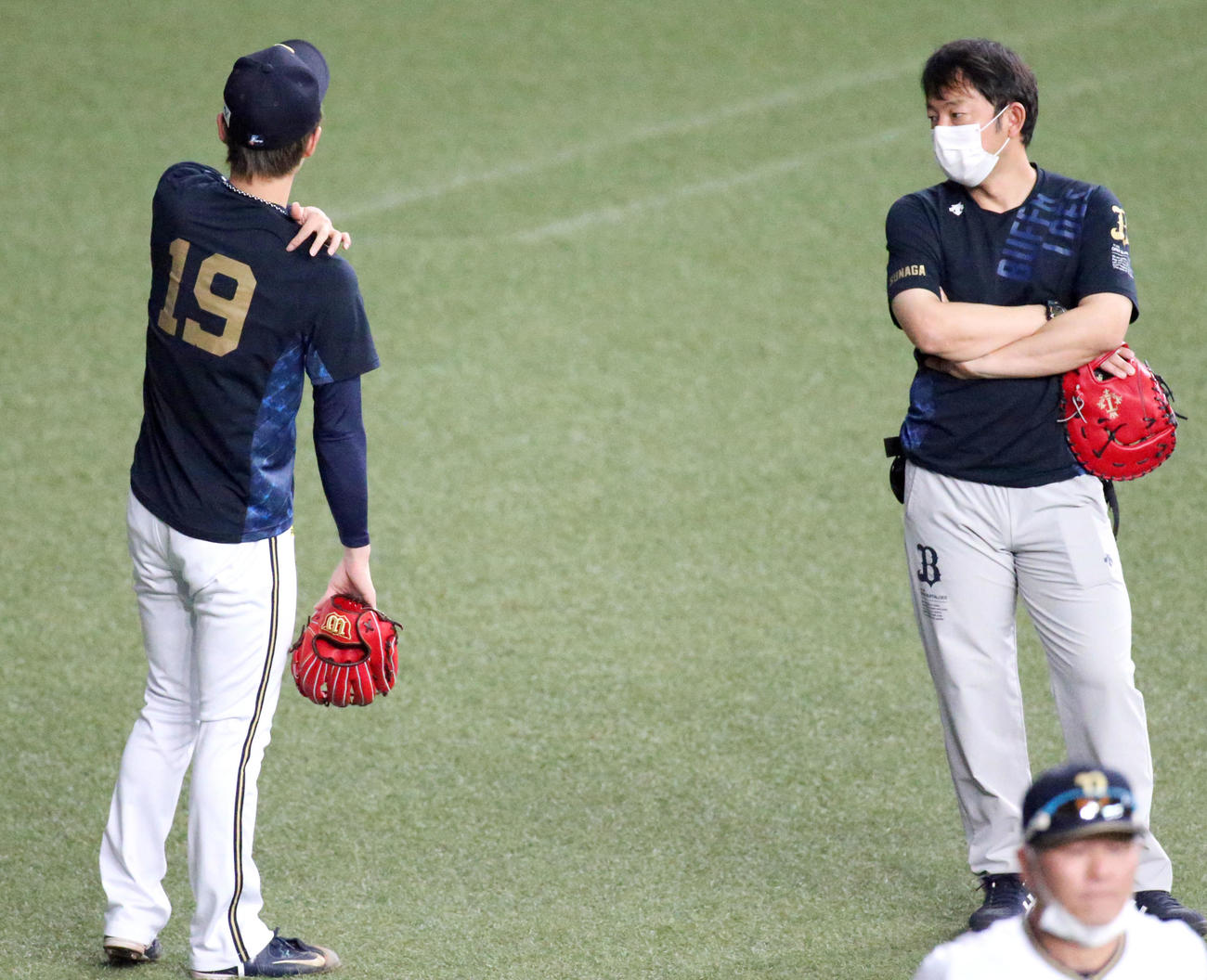 山岡（左）は、キャッチボールを中断し、右肩をさわる（撮影・上山淳一）