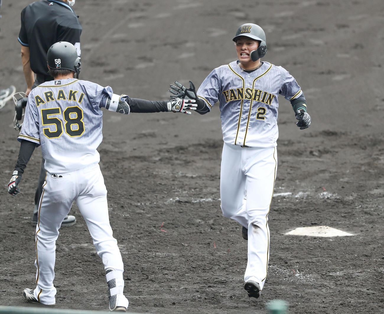 阪神紅白戦　5回表紅組無死一塁、梅野の適時二塁打で生還し、荒木（左）にタッチで迎えられる北條（撮影・前田充）