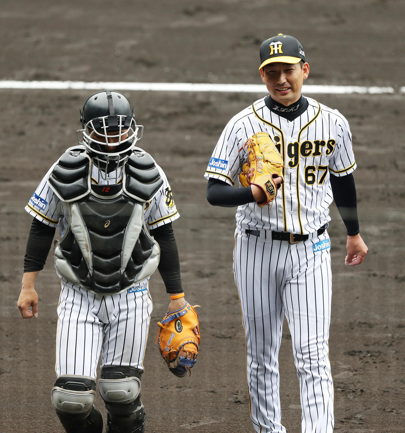 阪神紅白戦　4回表を3者凡退に抑えた岩崎（右）は坂本と言葉を交わしながら笑顔でベンチへ戻る（撮影・前田充）