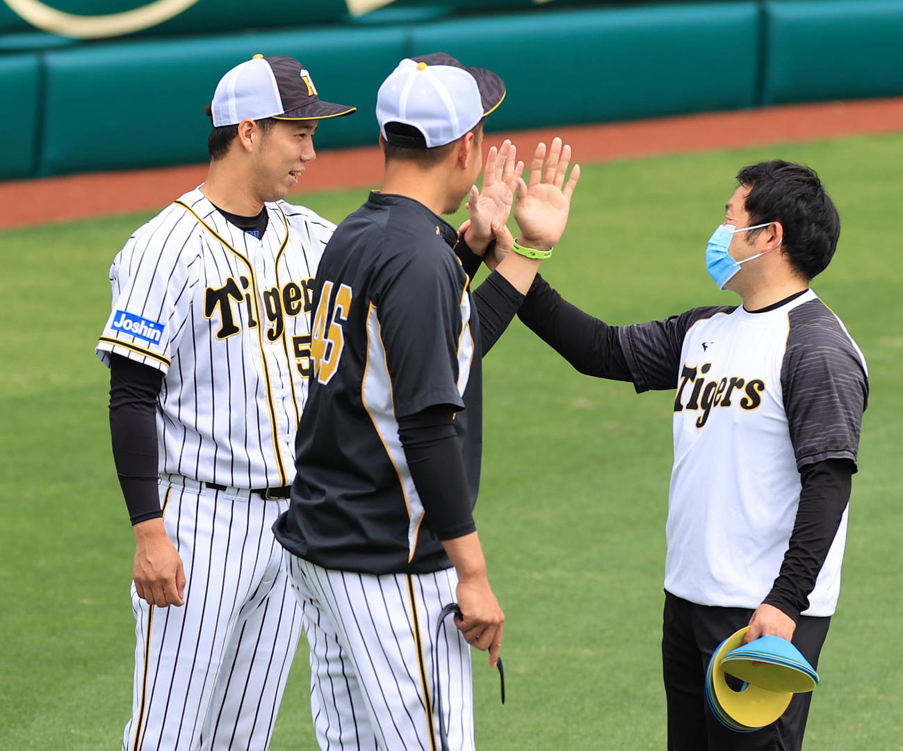 トレーナーに手の平をみせる青柳晃洋（左）と秋山拓巳（中央）（撮影・清水貴仁）