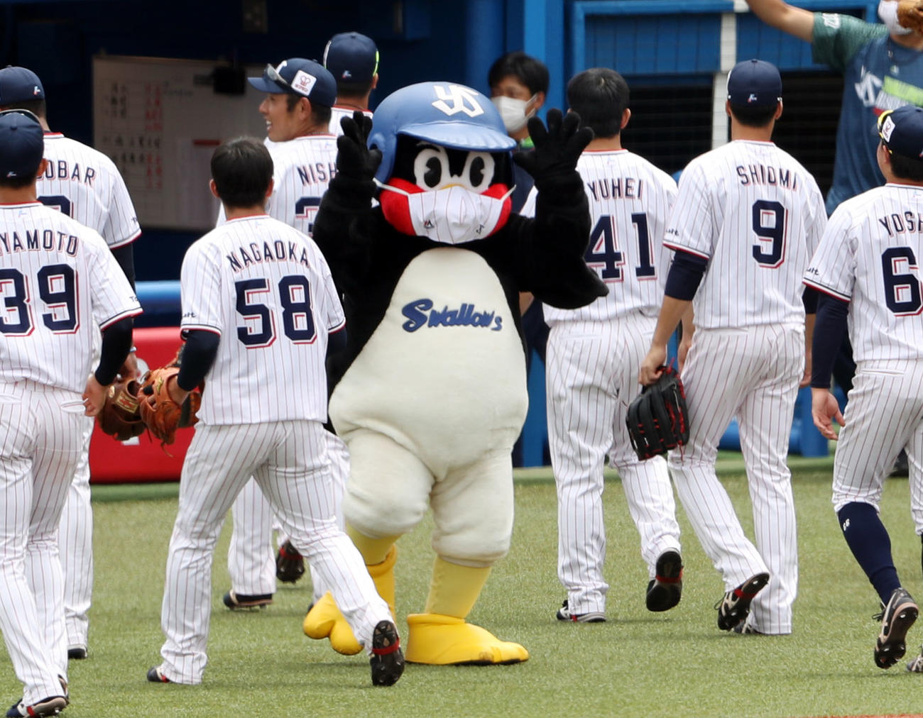 試合前、選手をエアタッチで迎えるつば九郎（撮影・狩俣裕三）