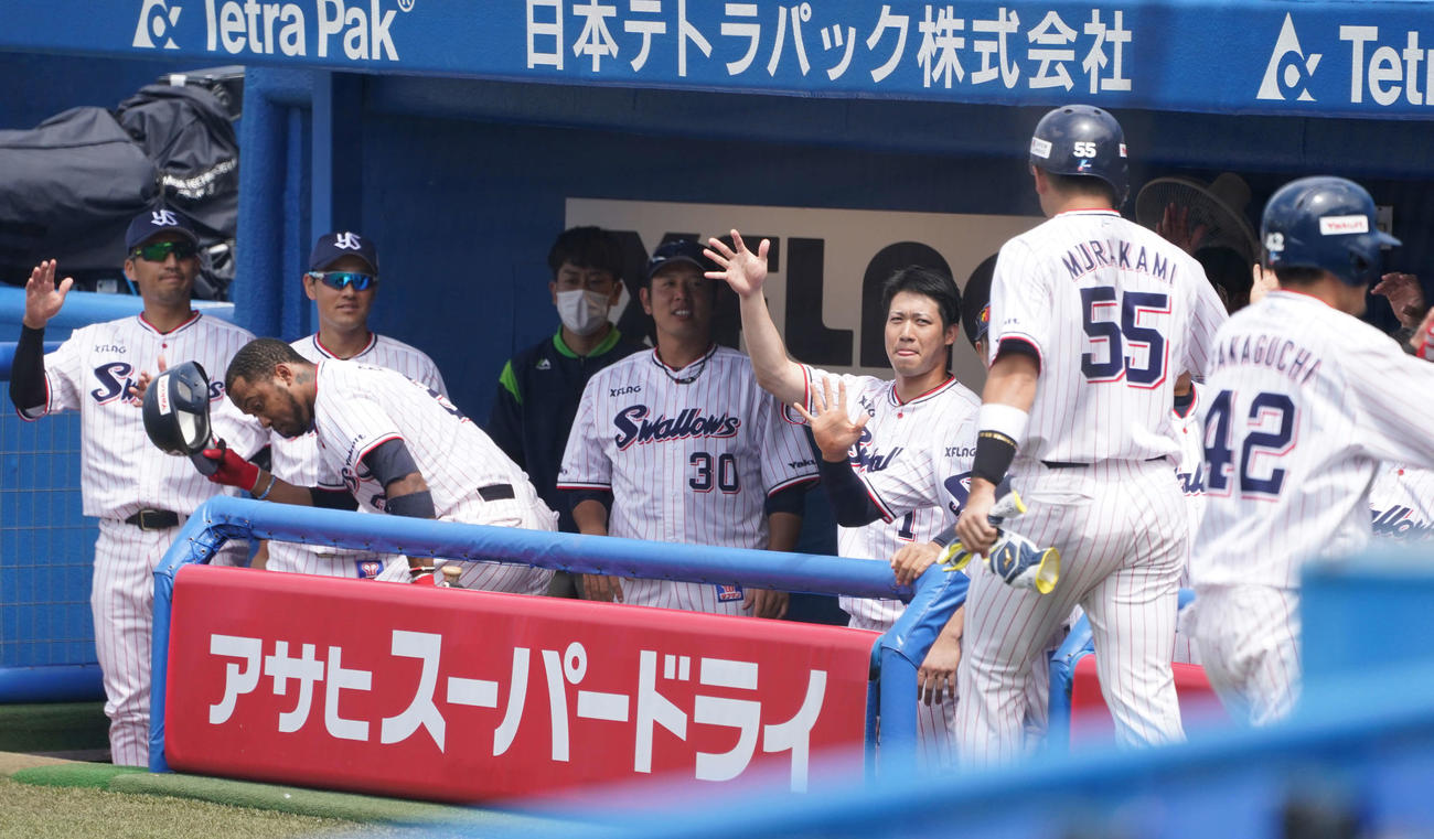ヤクルト対中日　1回裏ヤクルト2死一、二塁、塩見の2点適時三塁打で生還した村上（右から2人目）をエアハイタッチで迎える山田哲（中央右）らヤクルトナイン（撮影・鈴木みどり）