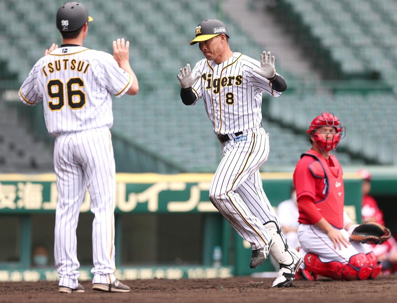 練習試合・阪神対広島　6回裏阪神1死、福留孝介は中越え本塁打を放ち筒井壮外野守備走塁コーチ（手前）とエアタッチ（撮影・上山淳一）