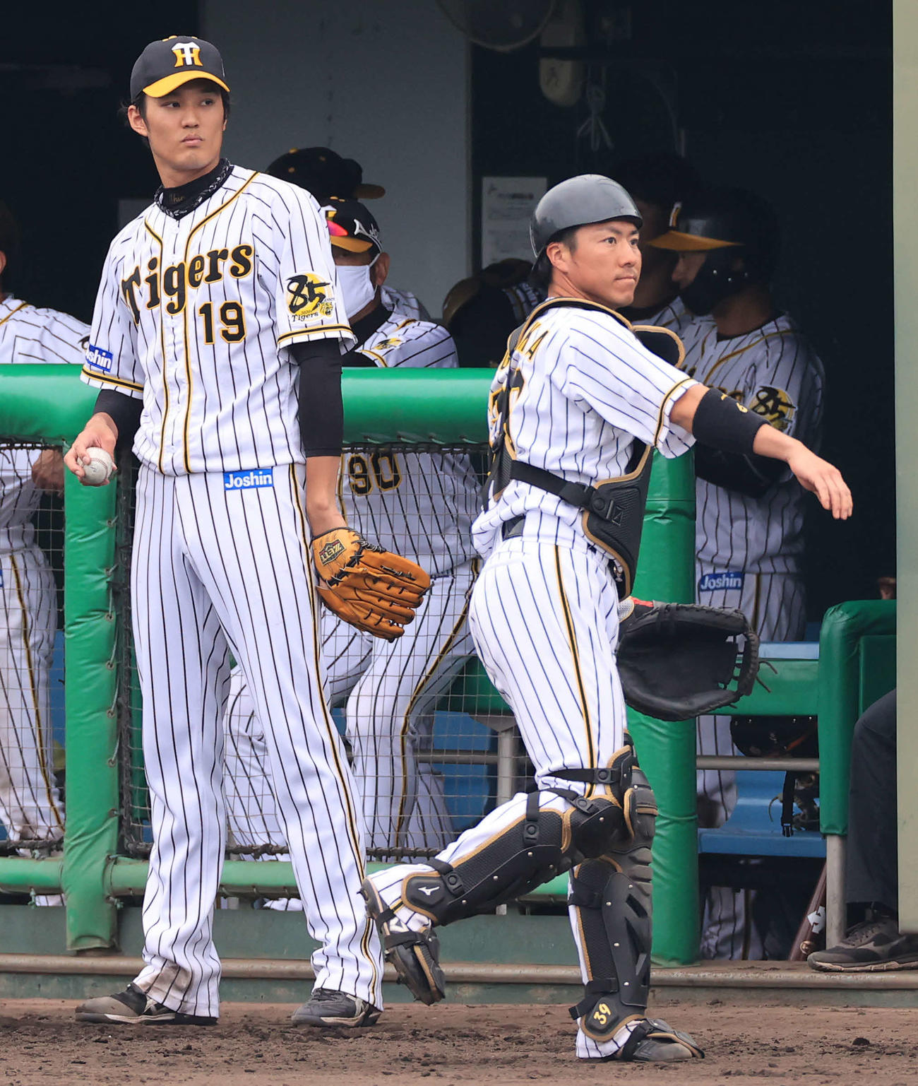 2軍練習試合　阪神対ソフトバンク　7回表ソフトバンクの攻撃中にベンチ前で準備する長坂（右）、左は藤浪（代表撮影）