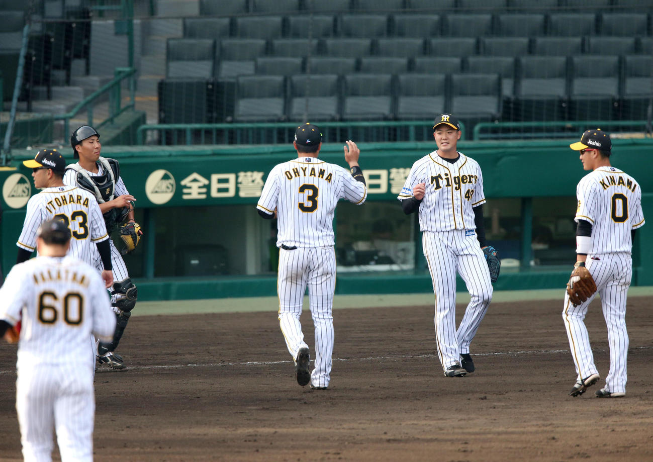 練習試合・阪神対広島　試合を締めた斎藤（右から2人目）とエアタッチする阪神ナイン（撮影・上山淳一）