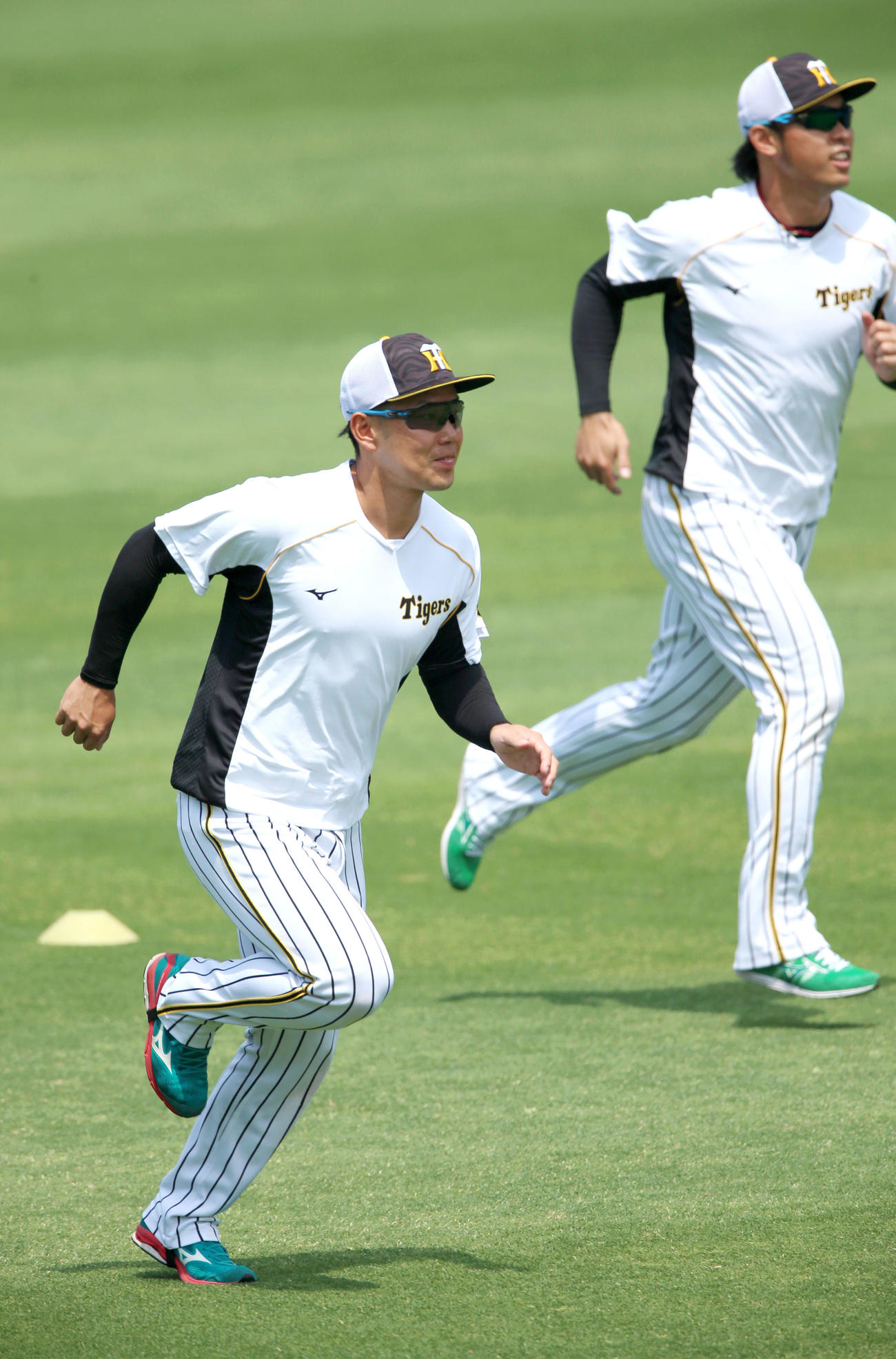 練習試合・阪神対広島　試合前、外野でダッシュする糸原（手前）と高山（撮影・上山淳一）