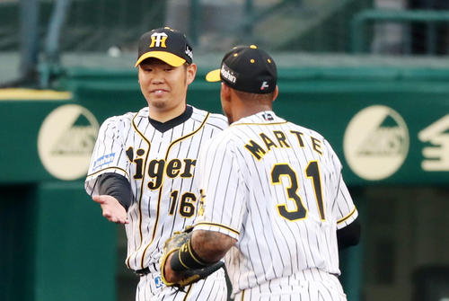 阪神対ソフトバンク 2回表、2度の好守備を見せたマルテ(右)を笑顔で迎える西勇(撮影・加藤哉)