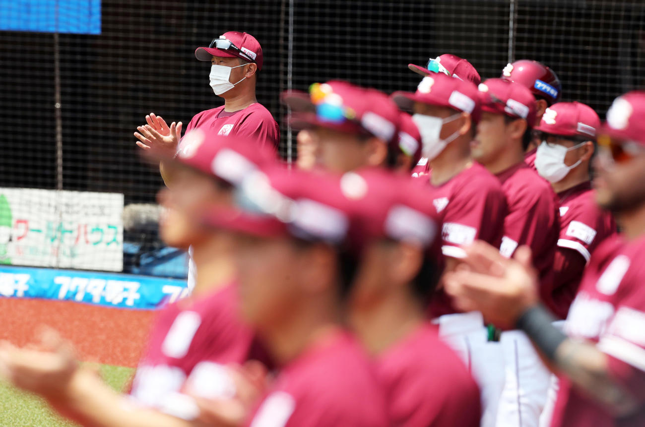 試合前、医療従事者に向け感謝の意味を込めて拍手を送る三木監督（左奥）ら楽天の選手たち（撮影・垰建太）