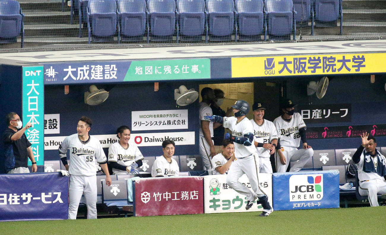 練習試合・オリックス対広島　5回裏オリックス無死、若月（手前右）は左越え本塁打を放ち、ベンチの出迎えにエアタッチで答える（撮影・上山淳一）