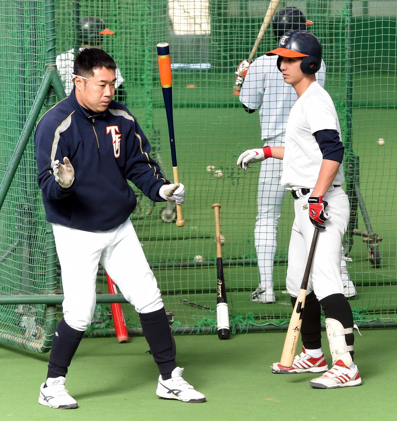 真剣な顔つきで選手に打撃指導する東北福祉大・大塚監督（2017年2月16日撮影）