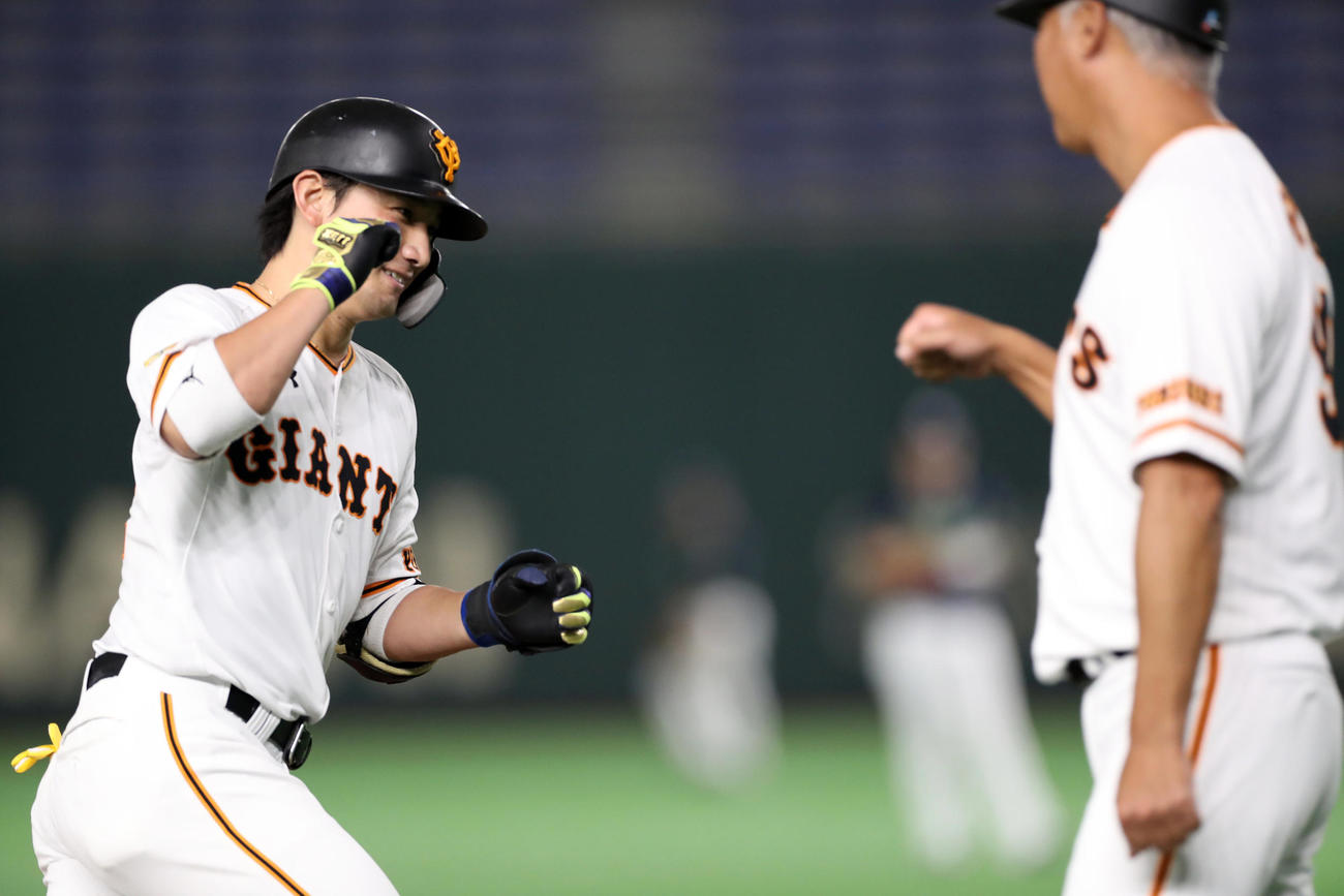 ト　4回裏巨人2死、ソロ本塁打を放ち、後藤コーチ（右）とエアタッチをする小林（撮影・狩俣裕三）