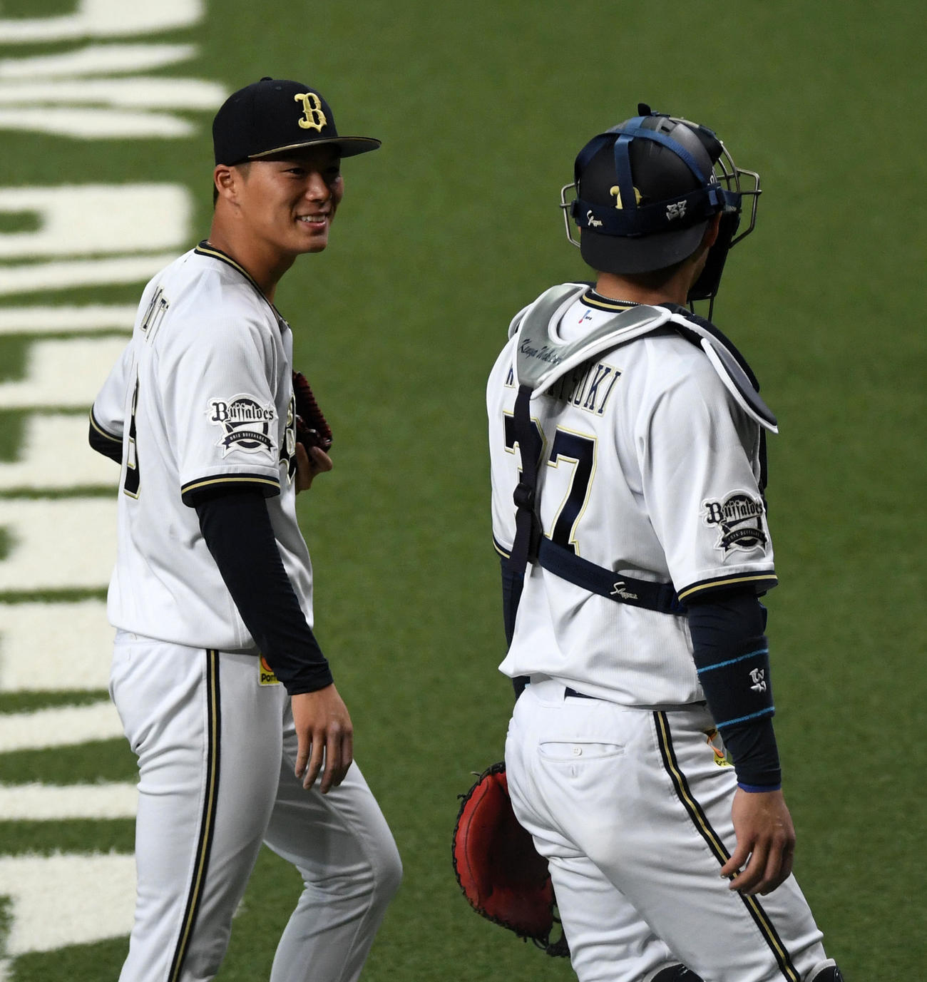 練習試合オリックス対広島　1回、笑顔でベンチに戻るオリックス先発の山本由伸（左）。右は若月健矢（撮影・前岡正明）