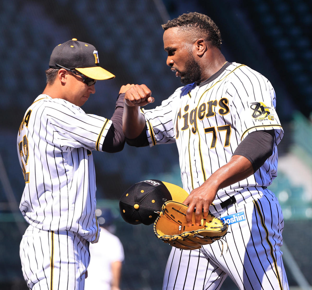 練習試合阪神対ソフトバンク　4回も無失点に抑え植田（左）と肘タッチを交わすガルシア（撮影・清水貴仁）