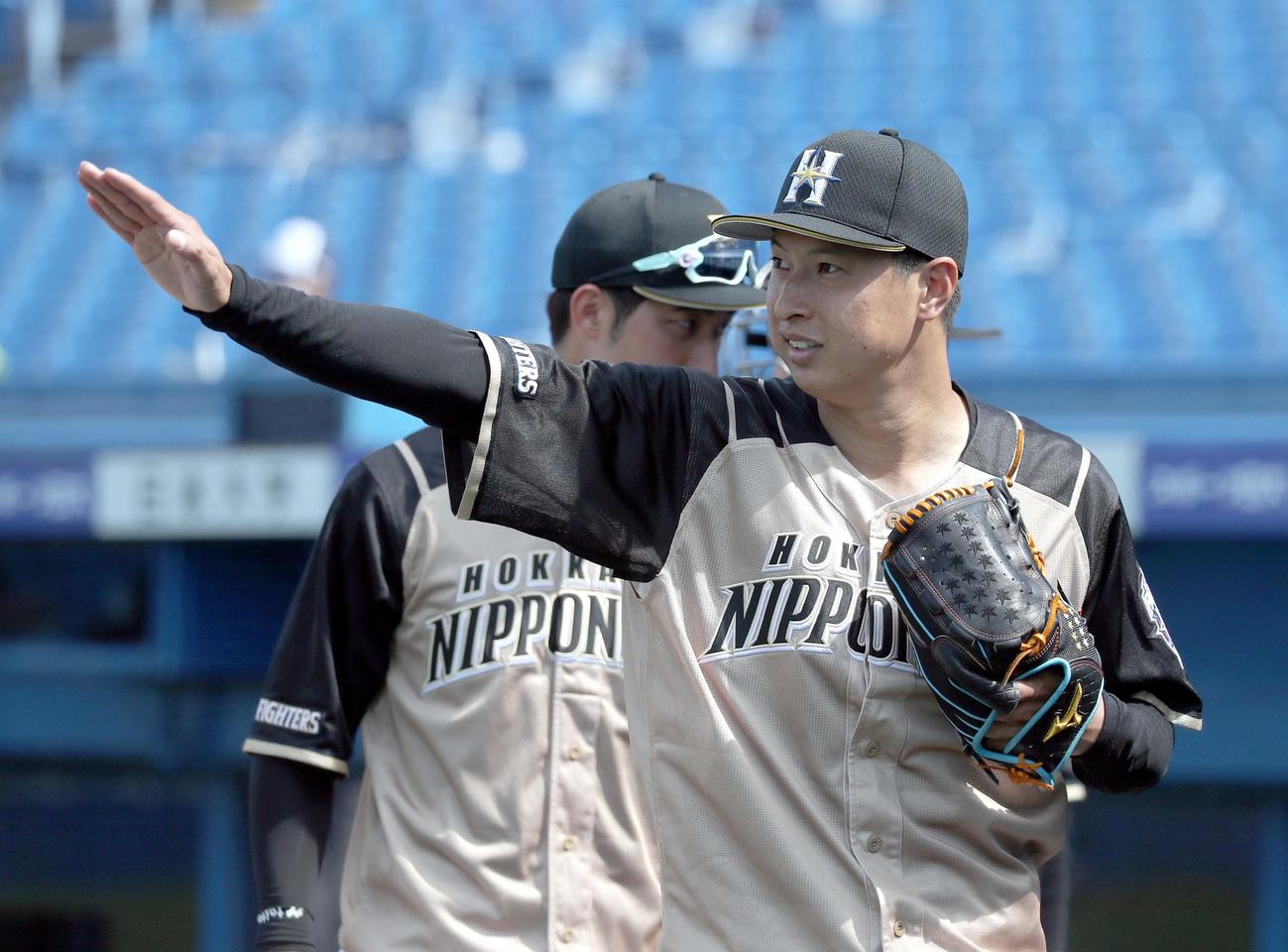 ヤクルト対日本ハム　日本ハム西川に手を振りながらベンチに戻る村田（撮影・佐藤翔太）
