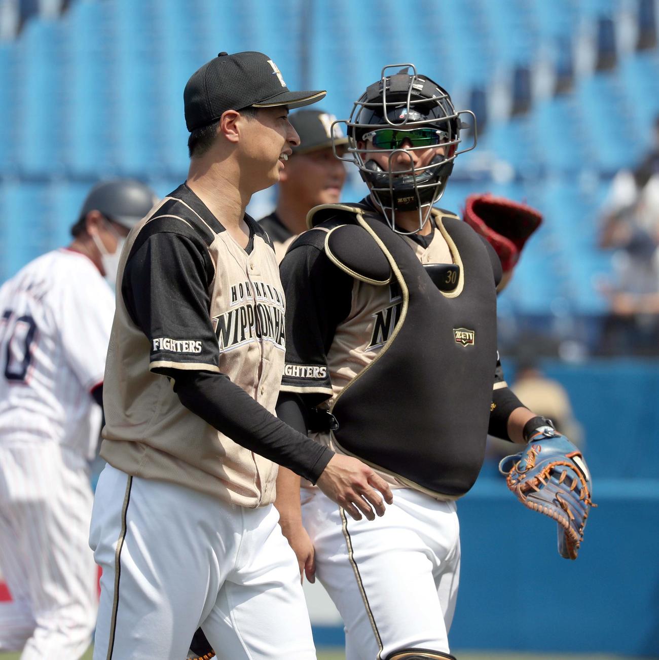 ヤクルト対日本ハム　会話しながらベンチに戻る日本ハム村田（左手前）と宇佐見（撮影・佐藤翔太）