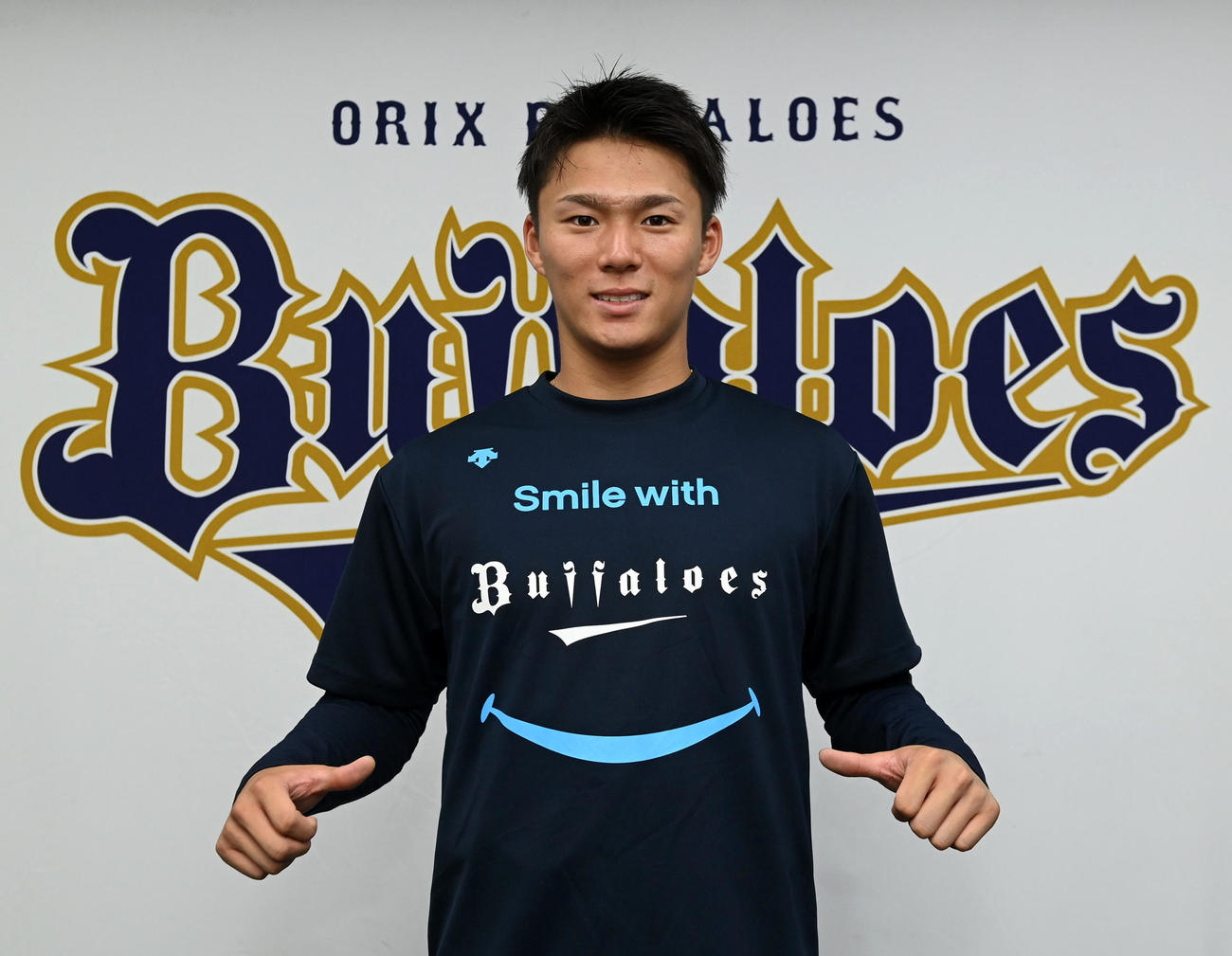 「野球で笑顔にTシャツ」を披露する山本